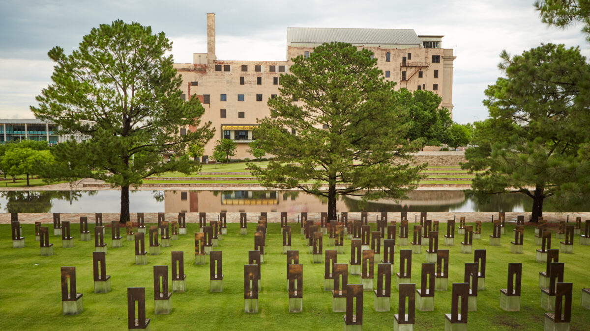 The Field of Empty Chairs fills the foreground, with the Reflecting Pool and Memorial Museum beyond.
